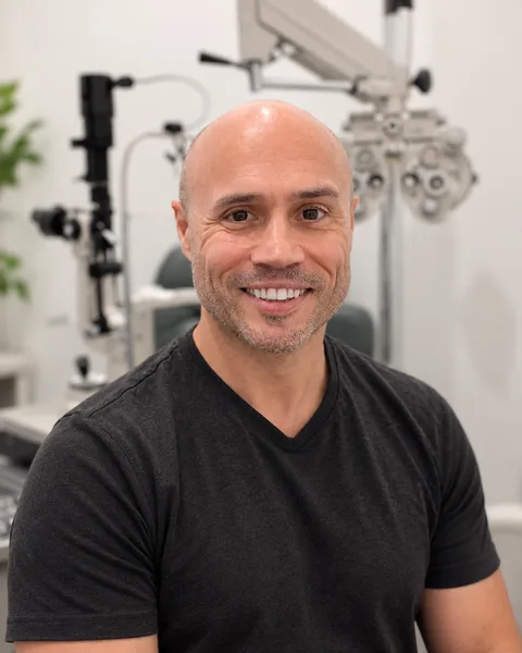 Justin Bazan, OD, smiling in an exam room at Park Slope Eye